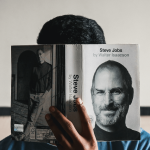 Man holding up a Steve Jobs biography book