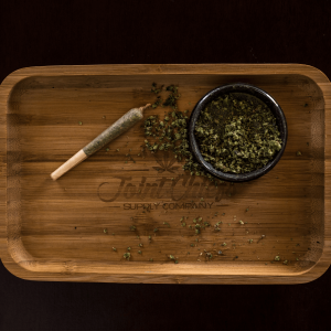 A rolling tray with a joint and grinder full of flower