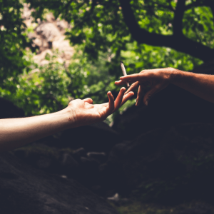 Two hands passing a joint