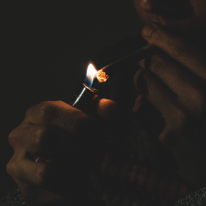 A person lighting a joint in the dark