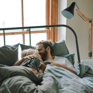 A happy couple cuddling in bed