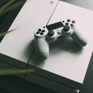 A white PlayStation and controller sitting on a table