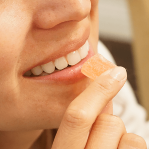 Woman smiling and holding orange cannabis edible