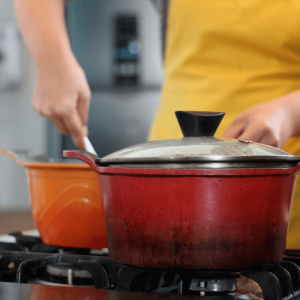 a person wearing an apron and stirring a pot