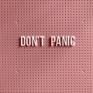 ‘Don’t Panic’ text on a pink pegboard 