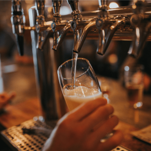 a person pouring beer from a tap