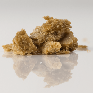 Dark gold cannabis concentrate sitting on a white surface
