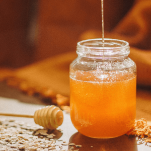 clear glass jar with honey poured into it