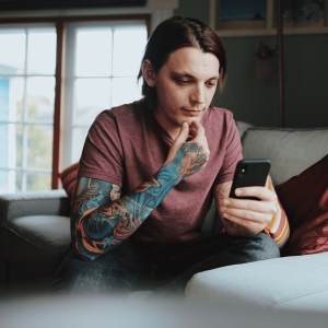 Man sitting on a couch and using his phone