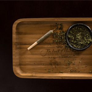 Ground cannabis flower and a joint on a rolling tray