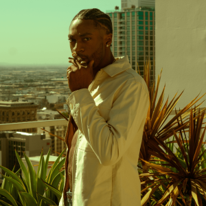A man in a white jacket smoking a blunt