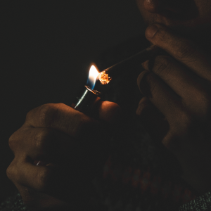 Man lighting the end of a blunt