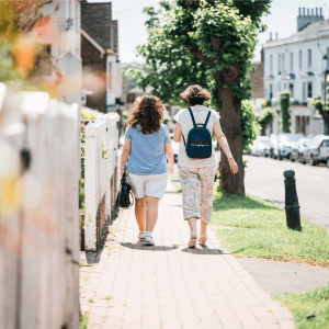 two women walking down a sidewalk