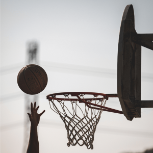 a person shooting a basketball into a hoop