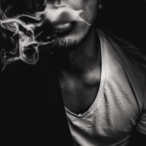 a black and white image of a man smoking weed