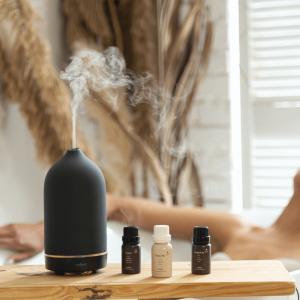 a woman lying in the bath with an essential oil diffuser nearby