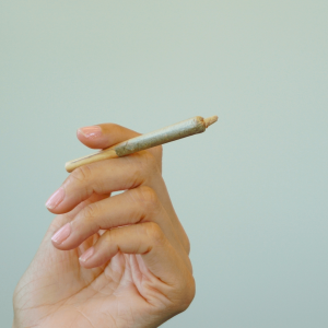 a person holding a cannabis joint