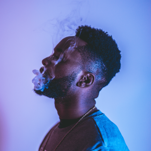 a man vaping in a purple-lit room