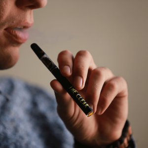 a man smoking a cannabis vape cartridge