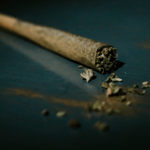 a brown joint packed with green cannabis flower