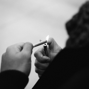 black and white photo of a person lighting a joint