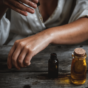 a woman applying oil to her arm 