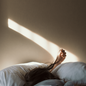 a woman with brown hair sleeping in a bed