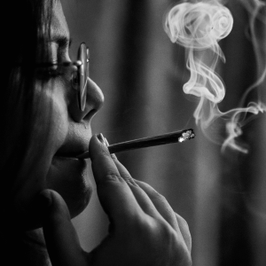 a black and white image of a woman smoking weed