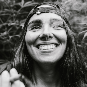 a black and white photo of a woman smiling and smoking weed