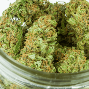 a glass jar of green cannabis nugs