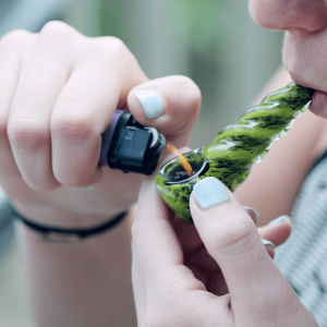 a person lighting a cannabis pipe
