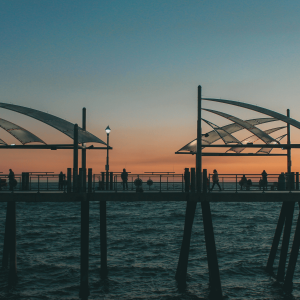 silhouette of people on a bridge at sunset