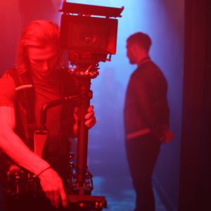 A Steadicam operator working in a dimly lit room