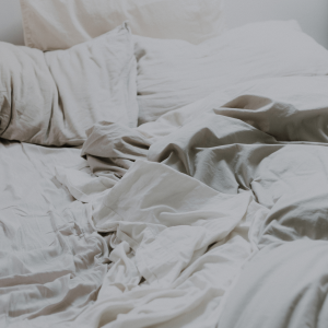 an unmade bed with white sheets