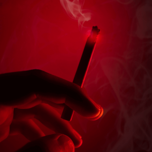 person holding a joint in a red room