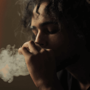a man smoking weed in grayscale photography