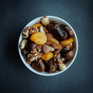a white bowl filled with various nuts, seeds, and dried fruits