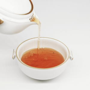 tea pouring into a white teacup