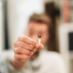 a person holding up the end of a joint