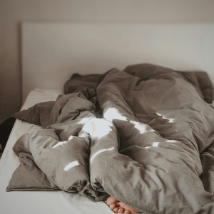 a person sleeping with their toes peeking out under brown sheets