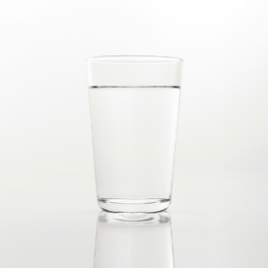 a clear glass of water in front of a white background