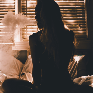 a woman sitting in bed and smoking