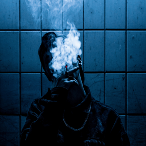 a man in a blue room smoking a joint