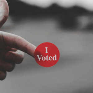 a person holding an ‘i voted’ sticker
