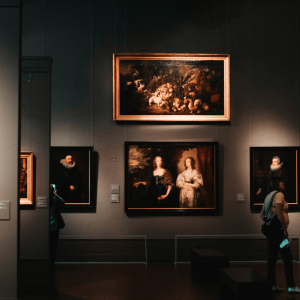 people looking at paintings in an art museum