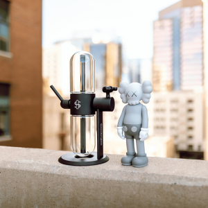 a black and glass percolator bong next to a silver robot