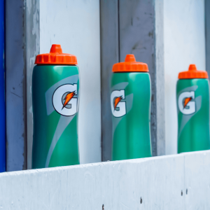 gatorade bottles lined up against a gray fence