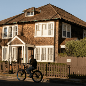 a person riding their bike past a house