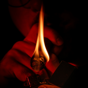 a person lighting a cigar