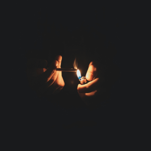 a person smoking a joint in a dark room